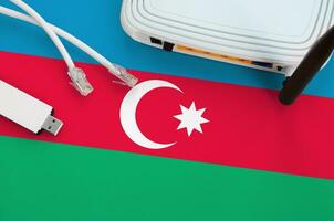 Azerbaijão bandeira retratado em mesa com Internet rj45 cabo, sem fio USB Wi-fi adaptador e roteador. Internet conexão conceito foto