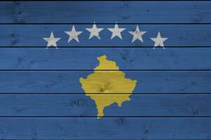 Kosovo bandeira retratado dentro brilhante pintura cores em velho de madeira muro. texturizado bandeira em rude fundo foto
