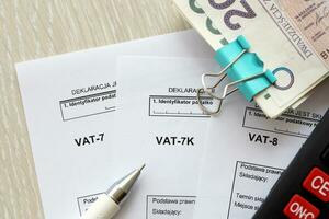 declaração para imposto em bens e Serviços IVA-8, IVA-7k, IVA-7 Formato em contador mesa com caneta e polonês zloty dinheiro contas foto
