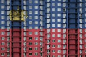 liechtenstein bandeira retratado dentro pintura cores em de vários andares residente construção debaixo construção. texturizado bandeira em tijolo parede fundo foto