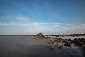 água do mar e recifes à beira-mar sob o céu azul foto