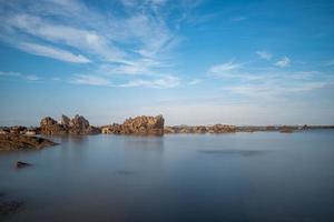 água do mar e recifes à beira-mar sob o céu azul foto