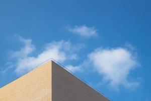 parte do edifício amarelo claro sob o céu azul e nuvens brancas foto