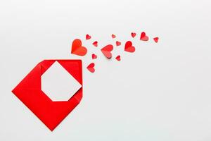 vermelho papel envelope com esvaziar branco cartão e coração em colori fundo. topo Visão dia dos namorados dia conceito foto