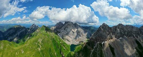 aéreo panorâmico Visão do volaia lago, Wolayersee, dentro a fronteira do Itália e Áustria com coglianos montanha dentro a fundo. nublado dia com alguns Sol abertura. vibrante cores. foto