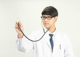 retrato jovem homem ásia aluna cientista ou médico 1 pessoa, vestindo branco vestido, de pé, olhando e sorridente estetoscópio auscultando a coração por aí dele pescoço. dentro laboratório quarto branco fundo foto