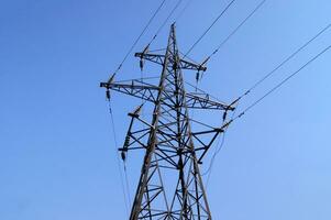eletricidade pilão, elétrico transmissão torre, contra azul céu fundo. foto