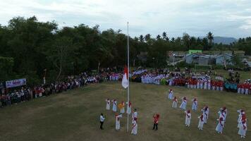 aéreo Visão do indonésio bandeira abaixando cerimônia testemunhado de aldeões. Indonésia independência dia foto