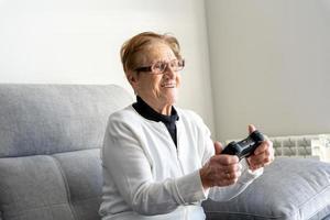 Mulher idosa encantada jogando videogame no console foto