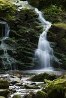 cascata e musgo coberto pedras foto