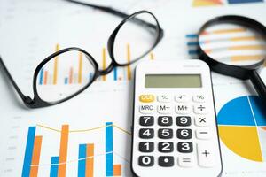 óculos com calculadora em gráfico gráfico papel. finança, conta, estatística, investimento dados economia, estoque troca negócios. foto