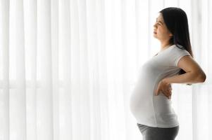 mulher grávida com dor nas costas foto