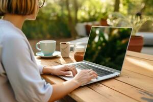 ai gerado fechar acima do uma mulher mãos digitando em uma computador portátil dentro uma acolhedor casa escritório configuração foto