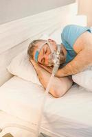 homem adormecido com problemas respiratórios crônicos considera usar máquina de cpap na cama. cuidados de saúde, terapia para apneia obstrutiva do sono, cpap, conceito de ronco