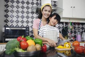 família feliz tem pai, mãe e sua filha cozinhando juntos na cozinha foto