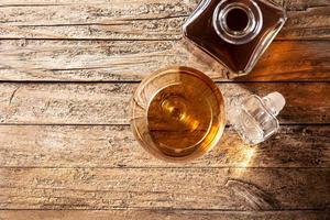 bebida conhaque ou uísque na mesa de madeira rústica foto