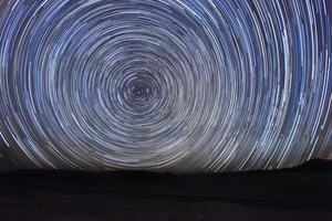 exposição noturna com trilhas de estrelas no céu