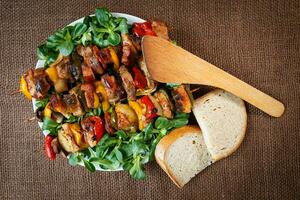 grelhado carne espetos com legumes e pão foto