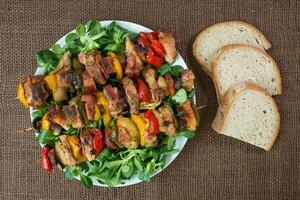 grelhado carne espetos com legumes e pão foto