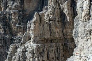 masculino montanha alpinista em uma através da ferrata dentro tirar o fôlego panorama do dolomites montanhas dentro Itália. viagem aventura conceito. foto