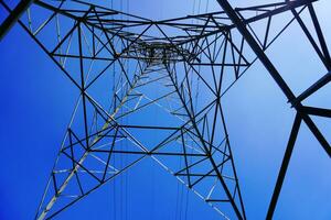 aço eletricidade pilone e Alto Voltagem poder linha eletricidade transmissão foto com azul céu fundo.