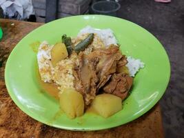 Visão do cozinhou frango servido em prato com arroz e legumes foto