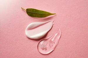 Cosmético gel e uma creme em uma Rosa fundo. foto