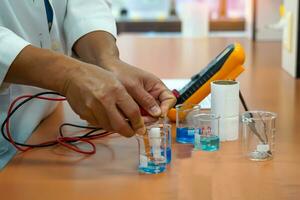 professor a medida elétrico atual de experimentando com criando uma galvânico célula, que é a eletroquímico célula este usa uma químico reação para produzir a elétrico atual. foto