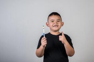 garotinho escovando os dentes em foto de estúdio