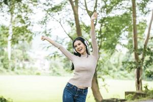 mulher asiática ouvindo música favorita em fones de ouvido. tempo feliz e relaxe. foto