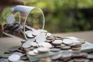 mão colocando moedas na jarra com a etapa da pilha de dinheiro crescendo e economizando dinheiro foto