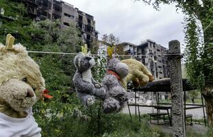 crianças brinquedos aguentar em uma corda contra a fundo do destruído queimado casas dentro Ucrânia foto