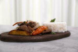 mãos segurando caçarola com uma típica peruano prato chamado lomo saltado. foto