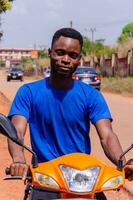 fechar acima do uma jovem bonito africano motociclista foto