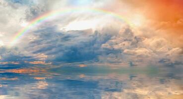 tormentoso mar antes tempestade com surpreendente arco Iris às pôr do sol foto