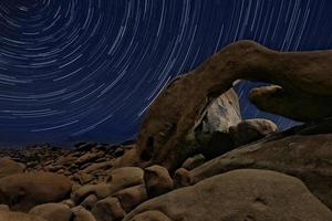 trilha noturna de estrelas percorre as rochas do parque joshua tree foto