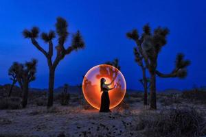 posando menina pintada de luz nas árvores do deserto de joshua tree foto