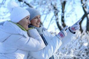 feliz mulheres dentro inverno roupas posando ao ar livre foto