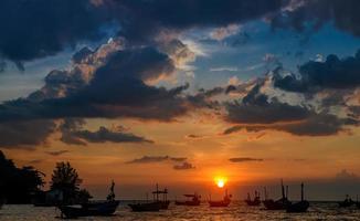 silhueta de barcos de pesca na hora do sol. foto