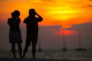 casal na praia ao pôr do sol foto