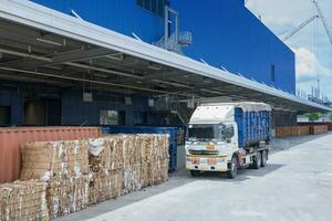 caminhão é carregando recipiente estacionamento dentro frente armazém foto