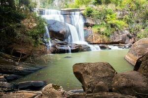 cascata dentro floresta com Rocha primeiro plano foto