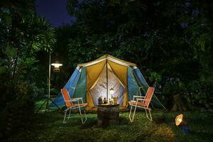 vintage cabine barraca, Antiguidade óleo lâmpada, retro cadeiras, grupo do acampamento tendas com ao ar livre fazer café instalações em de madeira mesas dentro uma floresta acampamento área dentro a floresta. foto