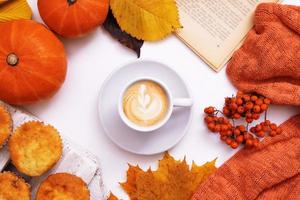 layout de outono aconchegante com café e folha de bordo, abóbora, suéter e livro foto