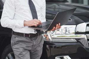 homem é um homem que trabalha em um laptop e testa em dispositivos móveis. foto