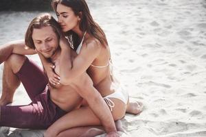 um casal romântico na praia em um maiô, lindos jovens sensuais