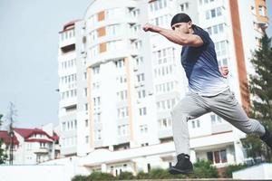 jovem esportes fazendo parkour na cidade. foto