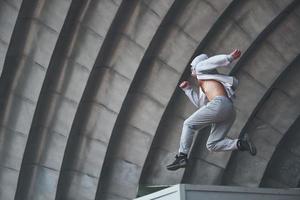 um jovem está pulando. parkour no espaço urbano, atividade esportiva. foto