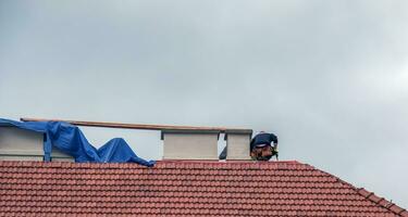 nitra, Eslováquia - 15/05/2023 faz-tudo reparar chaminés em a cobertura do uma casa. foto