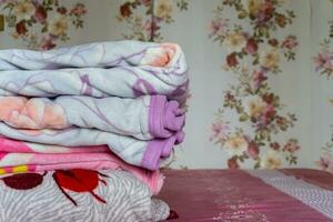 empilhado do colorida cobertor em Rosa cama. guardada Rosa cobertores. branco guardada edredon deitado foto